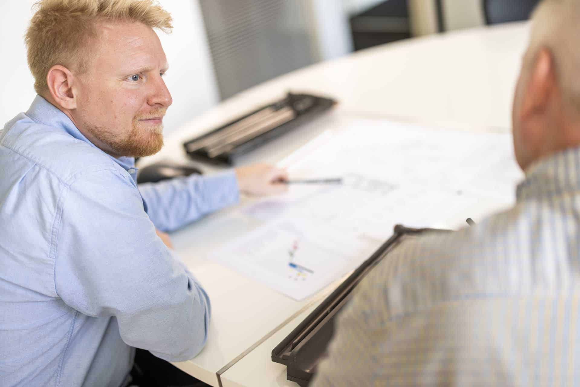 0U2A4432 Byggerådgiver gennemgår byggetegninger ved bordet