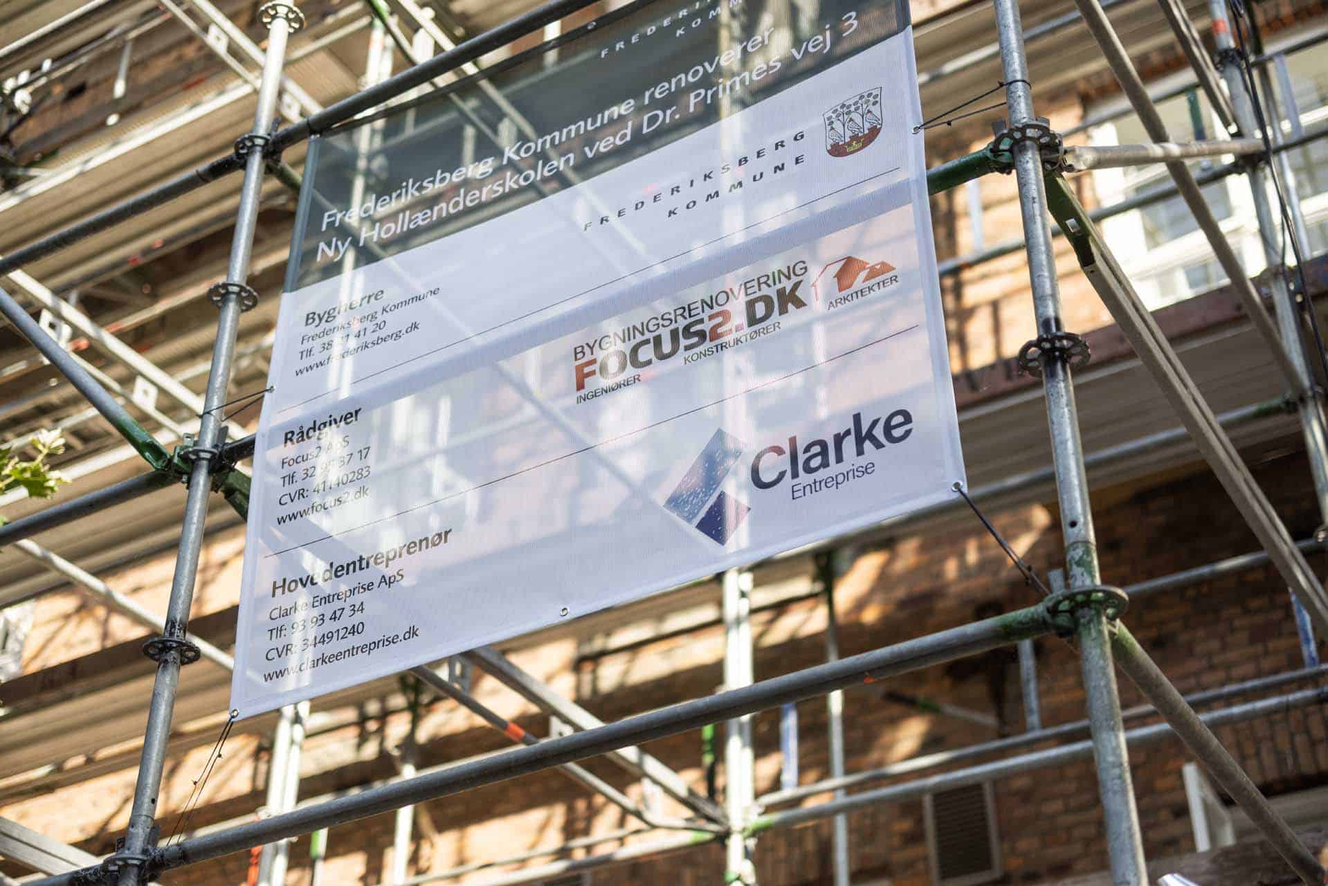 Byggeskilt på stillads, der viser renovering af Ny Hollænderskolen, et eksempel på arbejde fra en vedligeholdelsesplan. - "Frederiksberg Kommune renoverer Ny Hollænderskolen - Rådgiver FOCUS2.DK"