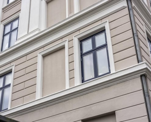 Enkelt vindue i beige facade med markerede fuger