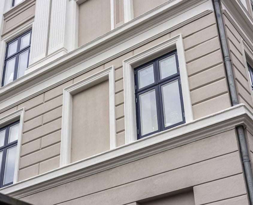 Enkelt vindue i beige facade med markerede fuger